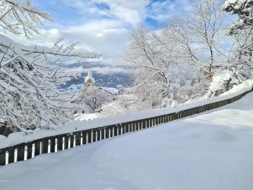 a snow covered yard with a church in the background at Apartment Sassun in Laion