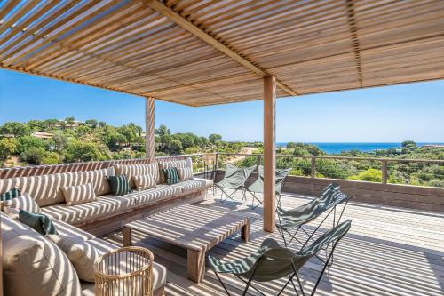 d'une terrasse avec des canapés et des chaises. dans l'établissement Superbe Villa Porto Vecchio vue mer plage à pied, à Porto-Vecchio