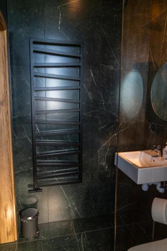 a bathroom with a sink and a shower at Bianco in Zawadka Brzostecka