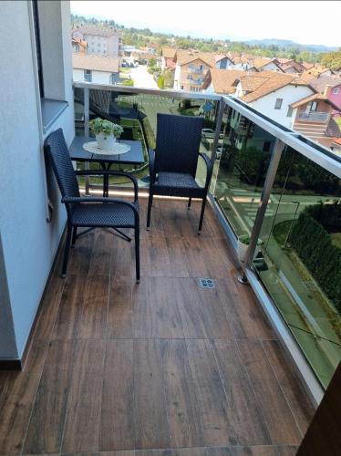 a balcony with two chairs and a table on it at Sunset in Teslić