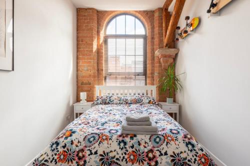 诺丁汉5 mins walk from centre, spacious city apt, open-plan的卧室设有一张砖墙内的大床