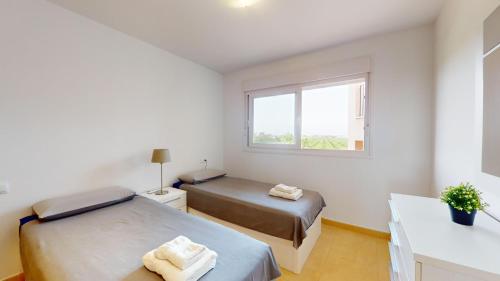 a bedroom with two beds and a window at Mar Menor Golf Resort in Murcia