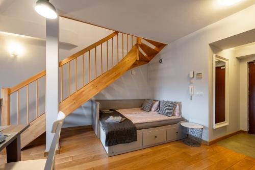 a living room with a couch under a staircase at Apartementy Plac Solny 20 in Wrocław