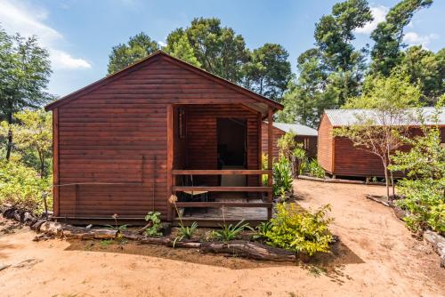 a small wooden building in the middle of a field at Die Boskombuis en Gastehuis in Rayton