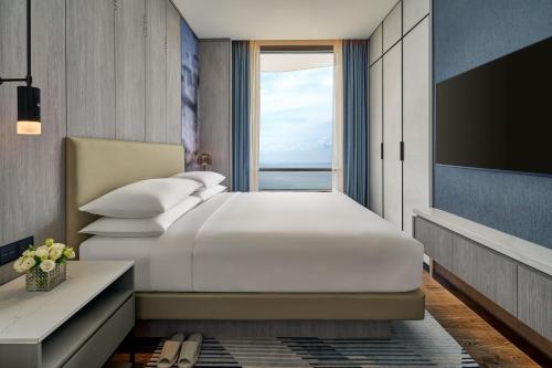 a bedroom with a large bed and a large window at Marriott Executive Apartments Penang in George Town