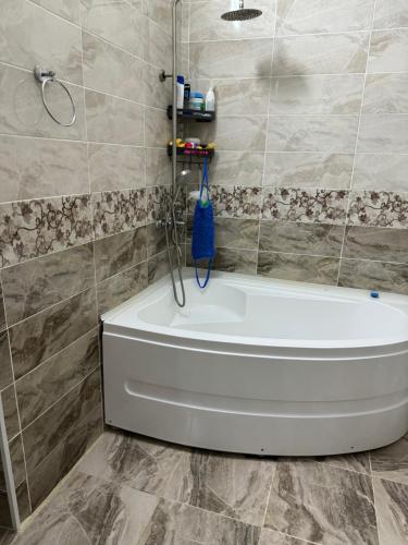 a bathroom with a white tub and a shower at Гостевой дом in Aralʼsk
