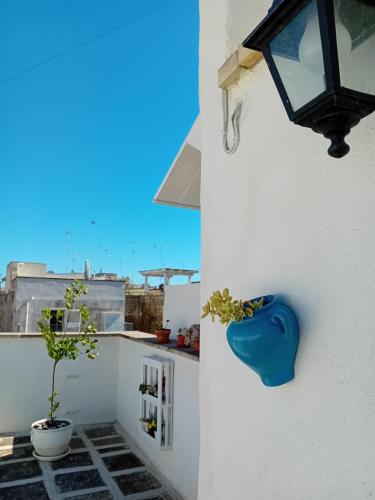 a blue vase on the side of a white wall at AREMU in Lecce