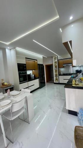 a large kitchen with white tile flooring and a table at Oasis TIFNIT Villa with Pool View No vis A vis in Draïd
