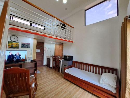 a bedroom with a bunk bed and a tv in it at The River House - Govantes Guesthouse in Vigan