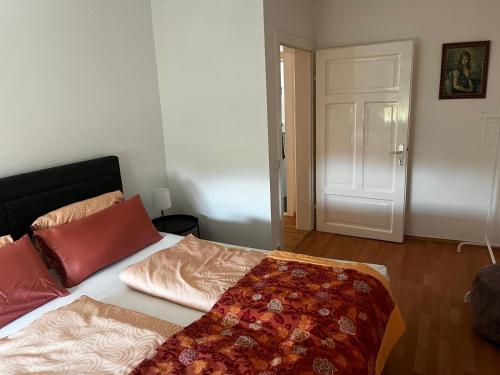 a bedroom with a bed with a red blanket on it at 80m2 am Kreuzbergl in Klagenfurt
