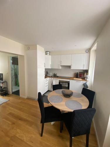 une cuisine avec une table et des chaises dans une pièce dans l'établissement Appartement confortable Stade de France, à Saint-Denis
