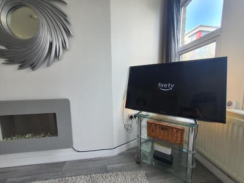 a flat screen tv on a glass table in a living room at 10 Pier Road Gillingham ME7 1RJ in Hoo