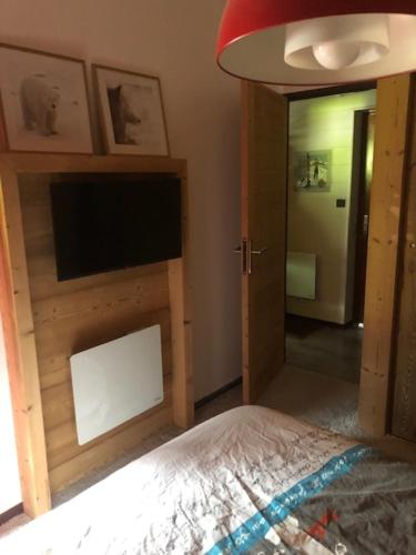 - une chambre avec un lit, une télévision et un miroir dans l'établissement Splendide vu sur les ARAVIS, à La Clusaz
