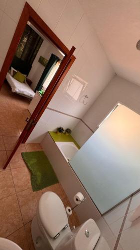 a bathroom with a white toilet and a mirror at Villa Feliza in Güime