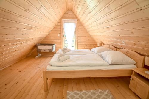 a bed with two teddy bears on it in a wooden room at Domek na Groniku in Zubrzyca Górna