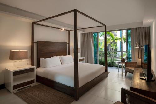 a bedroom with a canopy bed and a living room at The Ocean Club, a Luxury Collection Resort, Costa Norte in Sosúa