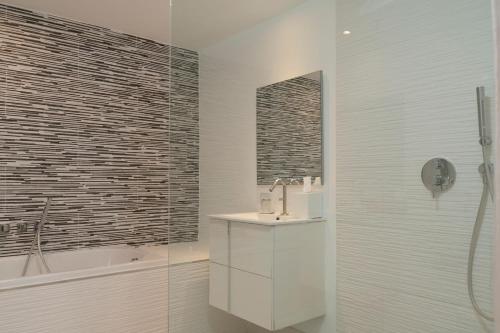 a bathroom with a sink and a shower and a tub at The Ocean Club, a Luxury Collection Resort, Costa Norte in Sosúa