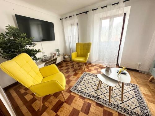 a living room with two yellow chairs and a table at Cozy 2BR apartment in Loriga by Soulplaces in Loriga