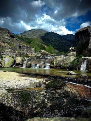 a group of waterfalls on a mountain with rocks at Cozy 2BR apartment in Loriga by Soulplaces in Loriga