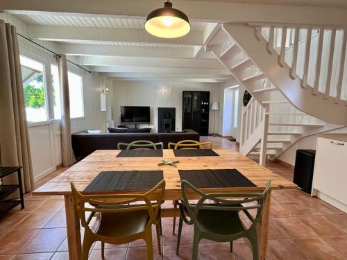 une salle à manger avec une table et des chaises et un escalier dans l'établissement LE GITE DE SOANI avec terrasse & jardin, à Saint-Évarzec