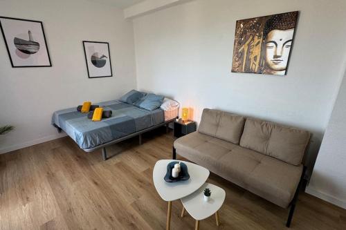 a living room with a bed and a couch at Sea views from the bed Design studio in Torrox