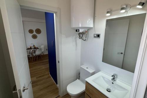 a bathroom with a toilet and a sink and a mirror at Sea views from the bed Design studio in Torrox