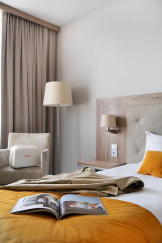 a hotel room with a book on a bed at Hotel Arche in Częstochowa
