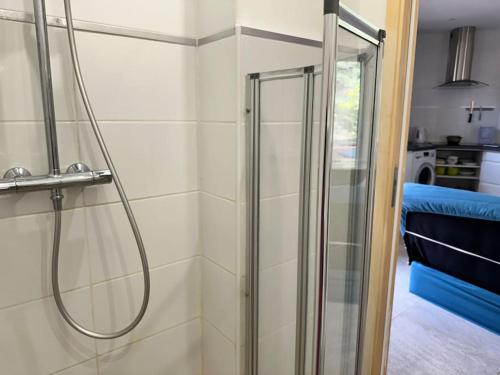 une douche avec une porte vitrée dans une salle de bain dans l'établissement Moderne Mini Maison, à Lézignan-Corbières