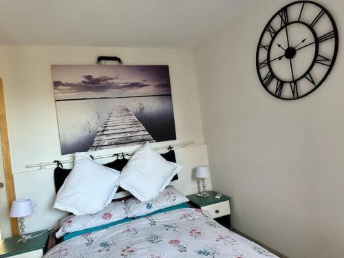 une chambre avec un lit et une horloge au mur dans l'établissement Moderne Mini Maison, à Lézignan-Corbières