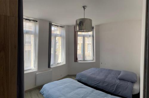 une chambre avec deux lits et deux fenêtres dans l'établissement Mariya Appart Moment, à Saint-Omer