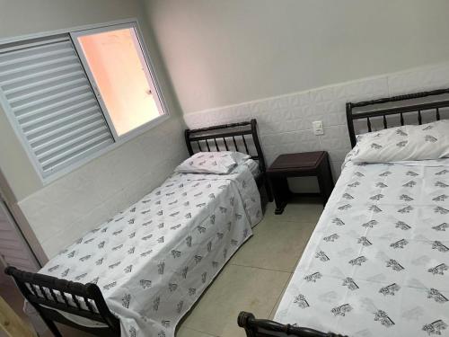two beds sitting next to each other in a bedroom at Pousadinha Dinos tour e cia in Uberaba