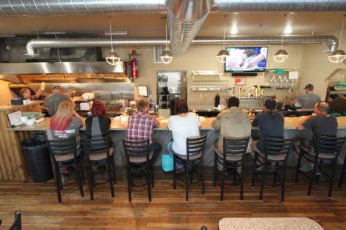 a group of people sitting at a bar in a restaurant at Bowman Lodge & Convention Center in Bowman