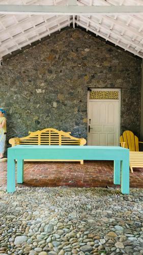 a blue bench sitting in front of a brick wall at Whispering House in Tangalle