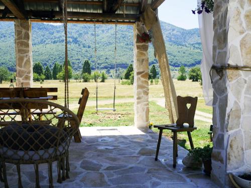 a patio with a table and chairs and a view at Chalet with Barbecue in Brezna in Pluzine