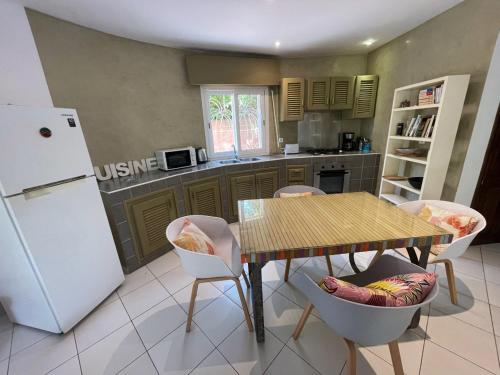 a kitchen with a table and chairs and a refrigerator at Agence Adjana Resort - Résidence du Port 3 in Sali Tapé