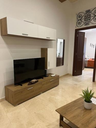 a living room with a large flat screen tv at Lucija's Guesthouse in Birżebbuġa