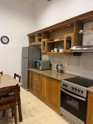 a kitchen with a stove and a refrigerator and a table at Lucija's Guesthouse in Birżebbuġa