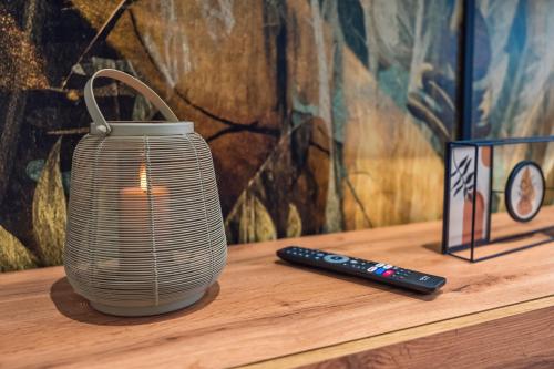 a vase sitting on a table next to a remote control at Stylisch - ruhig - gemütlich - zentral - einladend in Krefeld