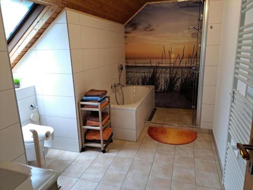 a bathroom with a bath tub and a sink at Ferienwohnung Heckenäcker in Ortenberg