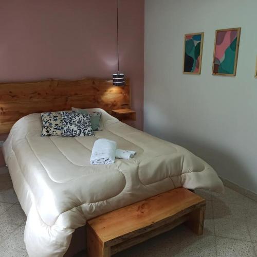 a bed with a wooden headboard and pillows on it at La Estrella 3 in Huerta Grande