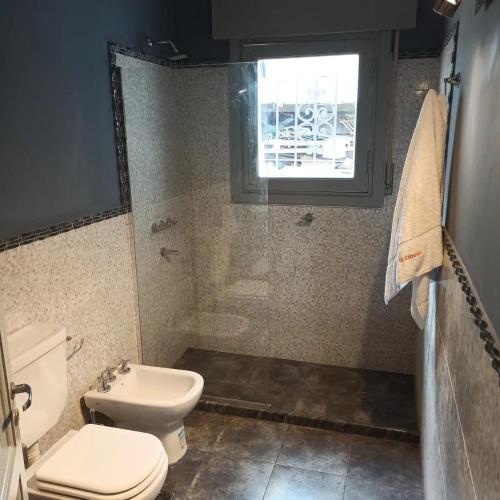 a bathroom with a toilet and a window at La Estrella 3 in Huerta Grande