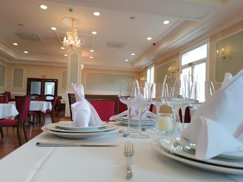 a dining room with a table with plates and glasses at Hotel Bossh Alicia in Albacete