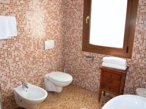 a bathroom with a toilet and a sink at Colombara Farmhouse in Mestrino