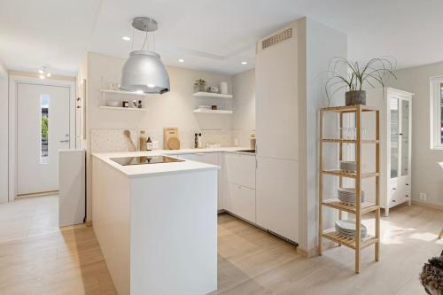 una cucina con armadi bianchi e piano di lavoro bianco di New and Urban Apartment, centrally located close to nature a Haugesund