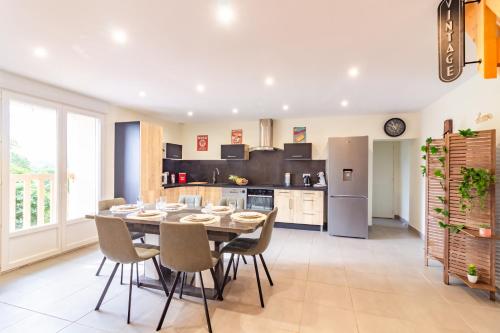 une cuisine et une salle à manger avec une table et des chaises dans l'établissement Le Gîte de la Route 999 - Belle maison de campagne, à Montlaur