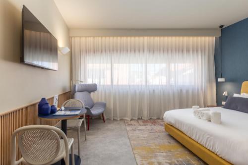 een hotelkamer met een bed, een bureau en een raam bij Aspasios Bonjardim Apartments in Porto