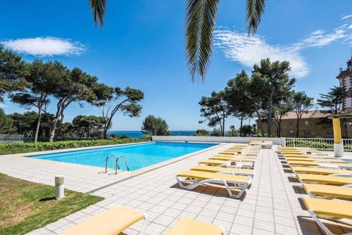 a row of lounge chairs next to a swimming pool at Seafront Unit 2 in Cascais