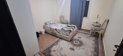 Un dormitorio pequeño con una cama y una alfombra. en one cozy bedroom, en New cairo