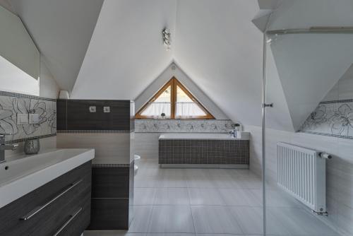 a bathroom with a shower and a sink and a window at Pienińska Przystań dom w Szczawnicy in Szczawnica
