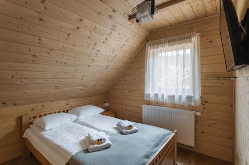 a bedroom with a bed in a wooden room at Pienińska Przystań dom w Szczawnicy in Szczawnica